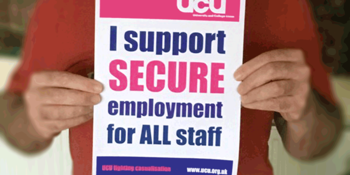 Person holding poster reading 'I support secure employment for all staff'